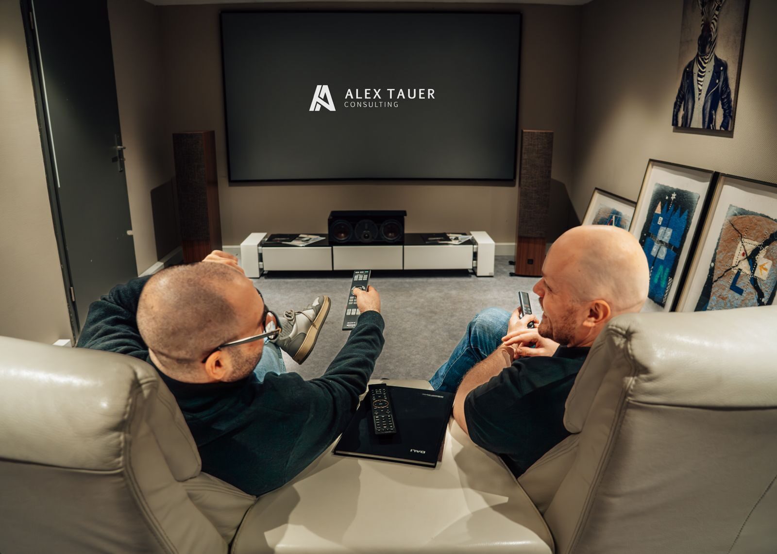 Heimkino-Vorführraum bei SoundBrothers mit Alex Tauer Consulting Logo auf der Leinwand